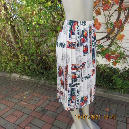 Eighty something permanent knife pleated skirt. White with navy/green/orange/red floral design.42/18