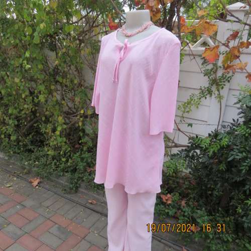 Carnation pink loose short sleeve top in bubble polyester.Slip over round neck with slit.Size 44/20.