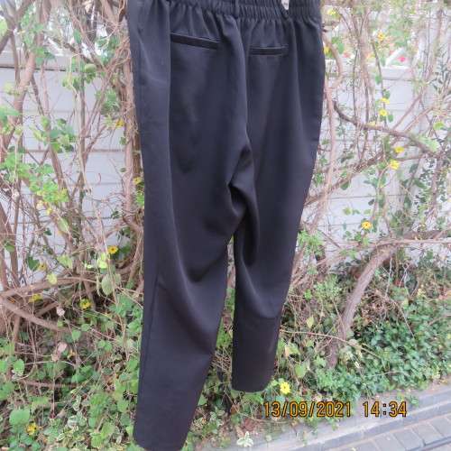 Smart black pants by PENNY C size 48/24. In polyester stretch fabric. Wide legs with some tapering.