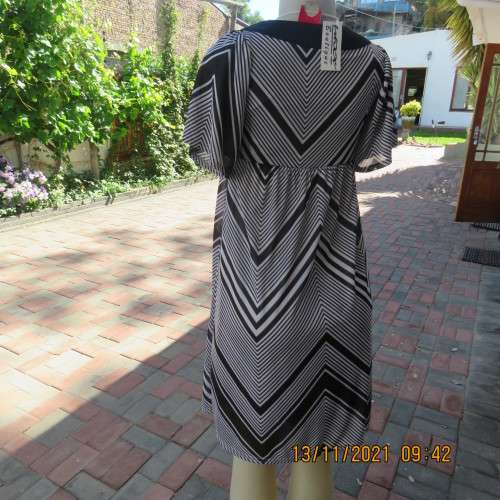 Stunning new short sleeve monochrome empire waist dress in soft silky 2 layer polyester.Size 32/8