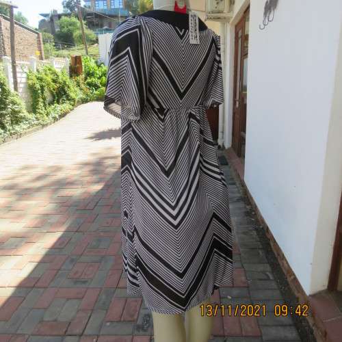 Stunning new short sleeve monochrome empire waist dress in soft silky 2 layer polyester.Size 32/8