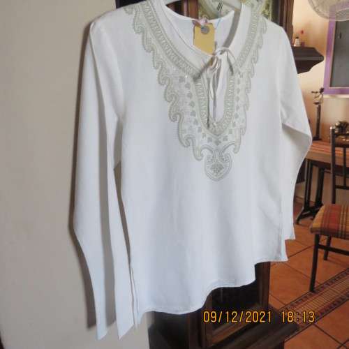Pretty white slip over round neck top with front slit and tiestring.Patterned neckline.For 11/12 yr.