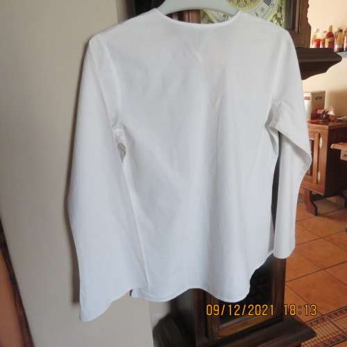 Pretty white slip over round neck top with front slit and tiestring.Patterned neckline.For 11/12 yr.