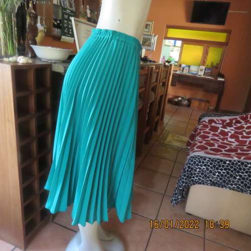 Emerald green permanent pleated flare skirt size 36 to 38. 100% polyester. Elasticated waist. As new