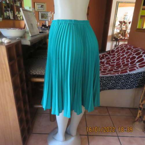 Emerald green permanent pleated flare skirt size 36 to 38. 100% polyester. Elasticated waist. As new