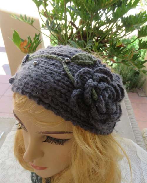 Chic bluegrey knitted hairband 12cm wide with knitted flower and green leaves on sides.As new.