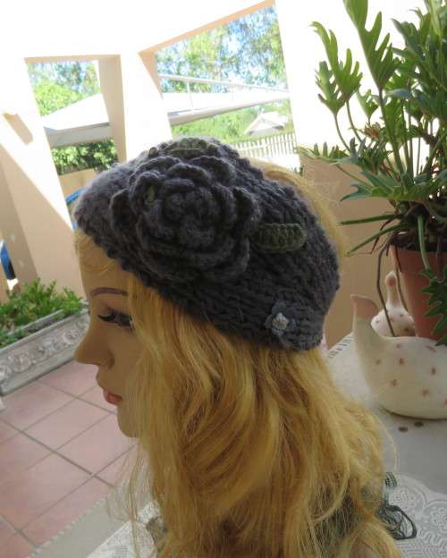 Chic bluegrey knitted hairband 12cm wide with knitted flower and green leaves on sides.As new.
