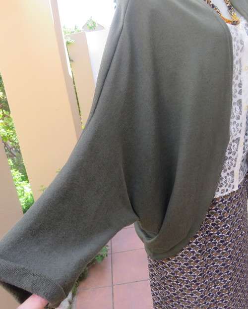 Knitted shrug in dark olive green polyester stretch knit.Size 42/18 by AMARA.Bolero front.As new.