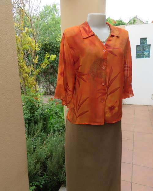 Bright orange/brick colour patterned button down top with collar by ZOEY size 36/12.Flare cuffs.