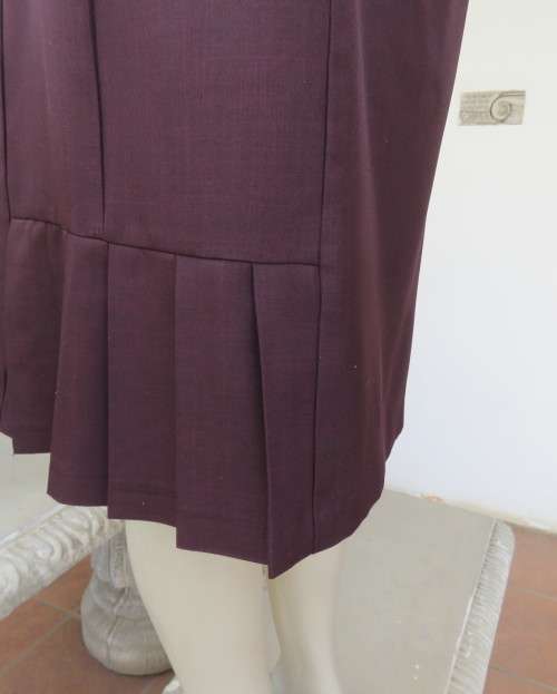 Elegant raisin colour medium length skirt.Bandless with zip at back.Pleats on bottom sides.Size 38