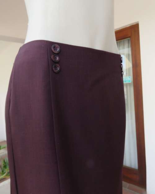 Elegant raisin colour medium length skirt.Bandless with zip at back.Pleats on bottom sides.Size 38