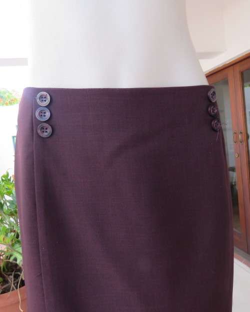 Elegant raisin colour medium length skirt.Bandless with zip at back.Pleats on bottom sides.Size 38