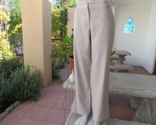 Elegant straight legged beige polycotton pants with some tapering.Med rise.Size 40/16.New condition.