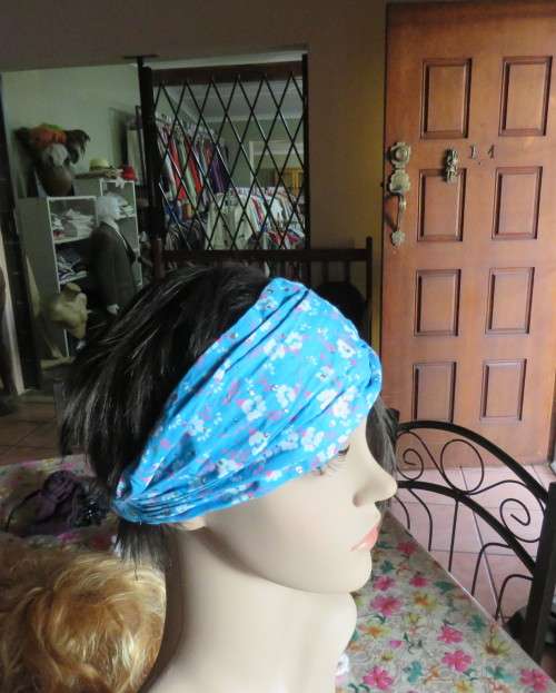 Skyblue folded polycotton hairband with white flowers and glitter.Elastic band at back.New condition
