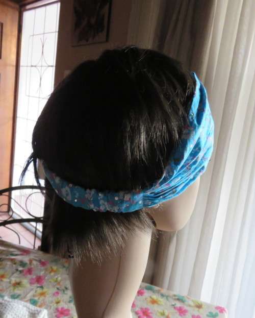 Skyblue folded polycotton hairband with white flowers and glitter.Elastic band at back.New condition