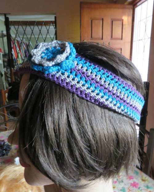 Pretty crochet acrylic hairband in purple/grey/blue stripes with flower.Purple braiding ties at back