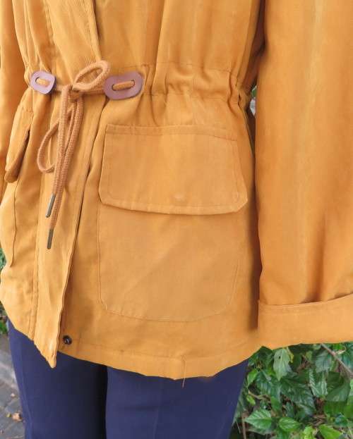 Fashion long sleeve jacket in mustard yellow.Grey hood.Drawstring in waist.Check lining.Size 34/10