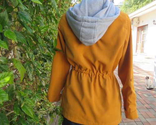 Fashion long sleeve jacket in mustard yellow.Grey hood.Drawstring in waist.Check lining.Size 34/10