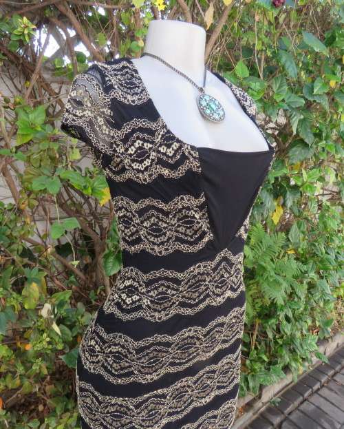 Stunning sexy evening bodycon in black stretch polyester with black/gold lace.Size 32 As new.