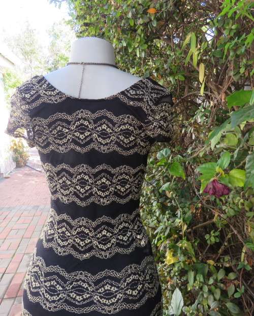 Stunning sexy evening bodycon in black stretch polyester with black/gold lace.Size 32 As new.