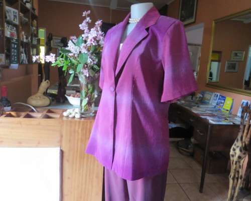 Feel sensational in this shiny short sleeve jacket in shades of pink/purple.Size 40 to 42. New cond.