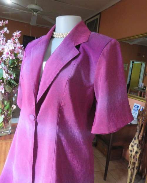 Feel sensational in this shiny short sleeve jacket in shades of pink/purple.Size 40 to 42. New cond.