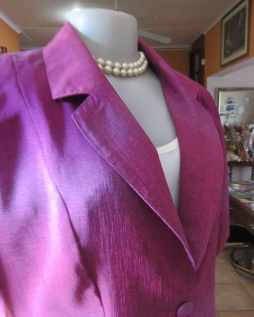 Feel sensational in this shiny short sleeve jacket in shades of pink/purple.Size 40 to 42. New cond.