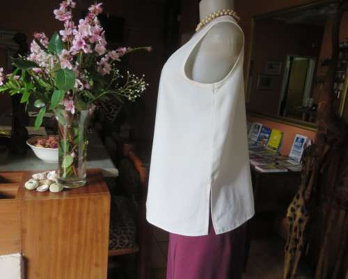 Cream cami style slip over silky polyester top by CONTRADICT size 36/12. Slits at sides.Scooped neck
