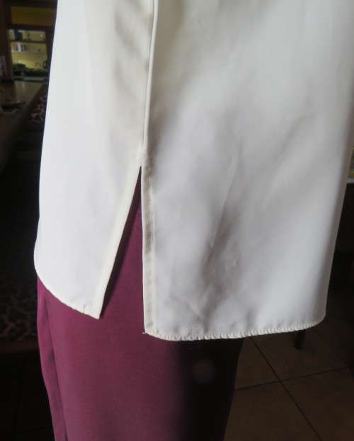 Cream cami style slip over silky polyester top by CONTRADICT size 36/12. Slits at sides.Scooped neck