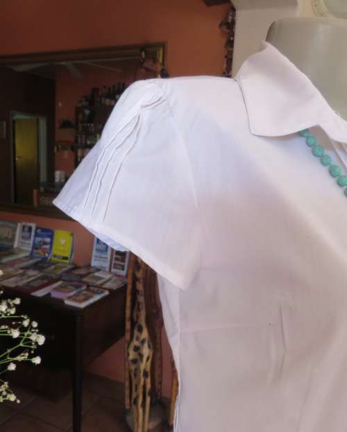 Charming white button down tailored top with tucked seams on front and capped sleeves.Size 34