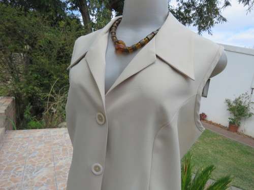 As new sleeveless cream top closing with 2 buttons and open collar. By SMILEY`S size 40/16.