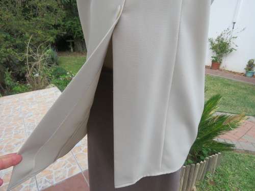 As new sleeveless cream top closing with 2 buttons and open collar. By SMILEY`S size 40/16.