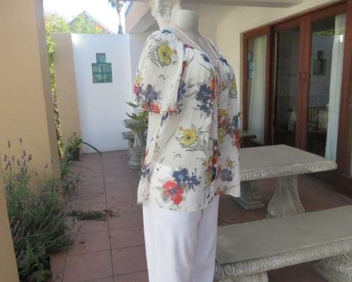 Dashing white floral peasant style top with wide elasticated neck.Bell sleeves.Size 38/14.As new