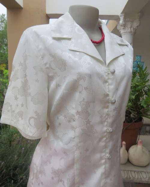 Shiny light cream tailored polyester satin short sleeve top with embossed patterns.Size 38/14.As new