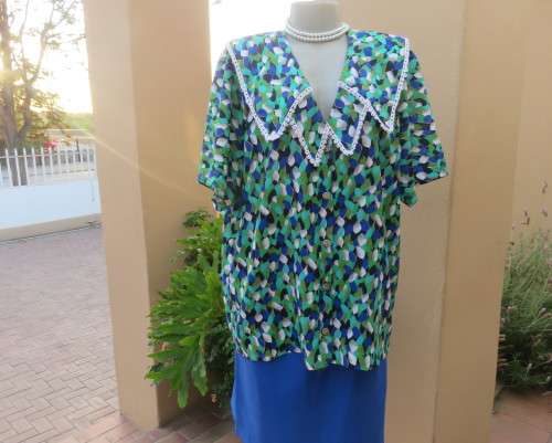 Striking 2 pc skirt suit in blues and greens.Short pencil skirt.Loose button down top.Size 42/18.