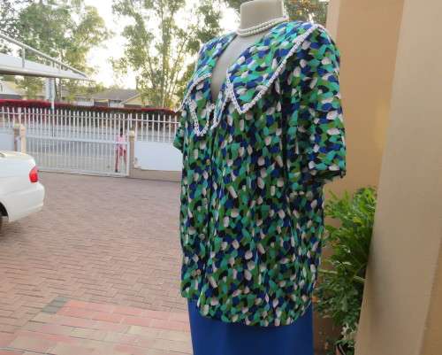 Striking 2 pc skirt suit in blues and greens.Short pencil skirt.Loose button down top.Size 42/18.