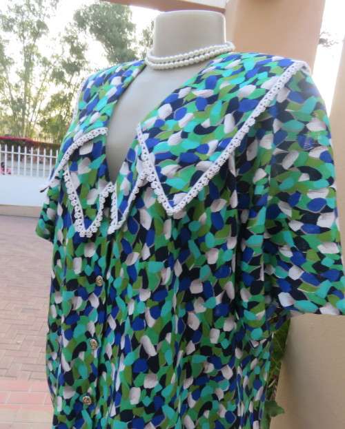 Striking 2 pc skirt suit in blues and greens.Short pencil skirt.Loose button down top.Size 42/18.