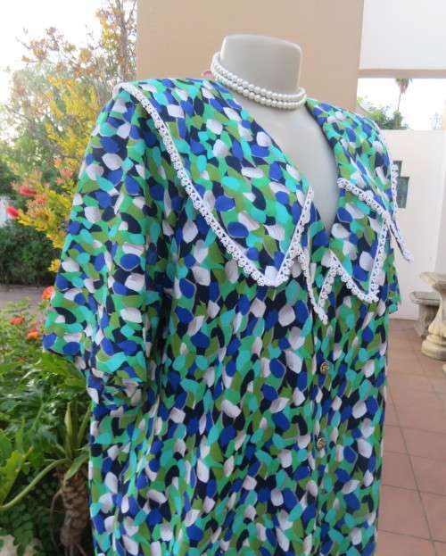 Striking 2 pc skirt suit in blues and greens.Short pencil skirt.Loose button down top.Size 42/18.