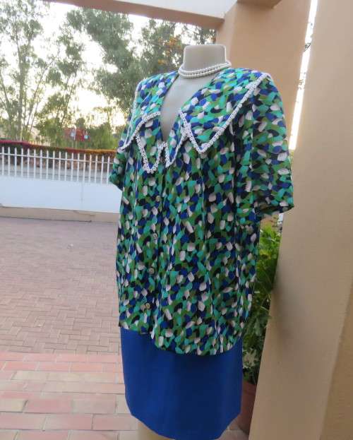 Striking 2 pc skirt suit in blues and greens.Short pencil skirt.Loose button down top.Size 42/18.