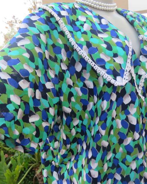 Striking 2 pc skirt suit in blues and greens.Short pencil skirt.Loose button down top.Size 42/18.