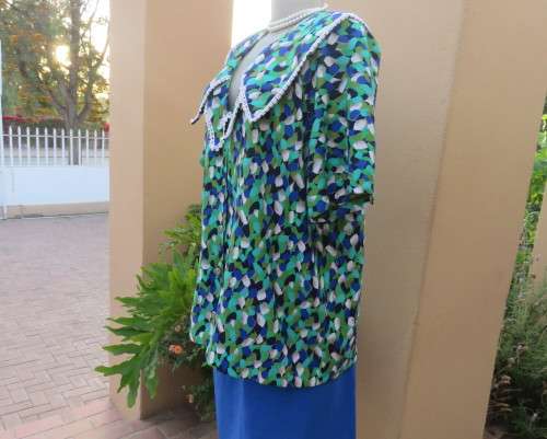 Striking 2 pc skirt suit in blues and greens.Short pencil skirt.Loose button down top.Size 42/18.