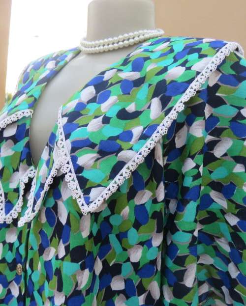 Striking 2 pc skirt suit in blues and greens.Short pencil skirt.Loose button down top.Size 42/18.