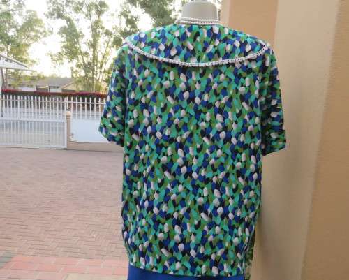 Striking 2 pc skirt suit in blues and greens.Short pencil skirt.Loose button down top.Size 42/18.