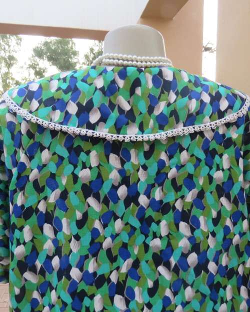 Striking 2 pc skirt suit in blues and greens.Short pencil skirt.Loose button down top.Size 42/18.