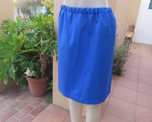 Striking 2 pc skirt suit in blues and greens.Short pencil skirt.Loose button down top.Size 42/18.