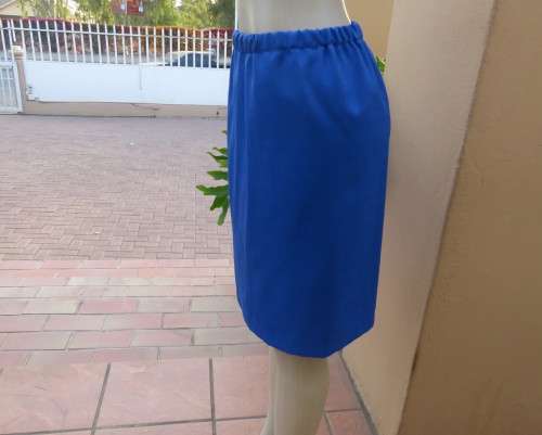 Striking 2 pc skirt suit in blues and greens.Short pencil skirt.Loose button down top.Size 42/18.