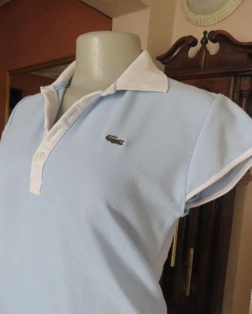 LACOSTE light blue top with white knitted collar and edging.Size 34 to 36.Opening in front.Good cond