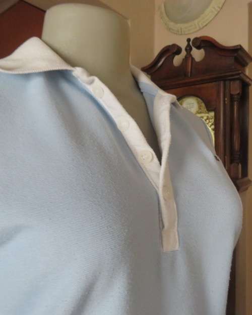 LACOSTE light blue top with white knitted collar and edging.Size 34 to 36.Opening in front.Good cond