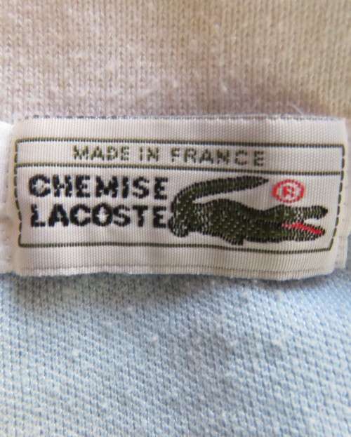 LACOSTE light blue top with white knitted collar and edging.Size 34 to 36.Opening in front.Good cond