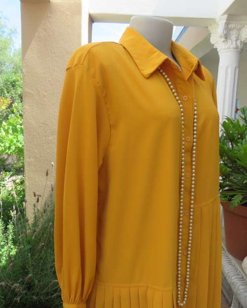 Uniquely styled long mustard top.Silky polyester.Button down.Right side longer.Size 38/40.As new